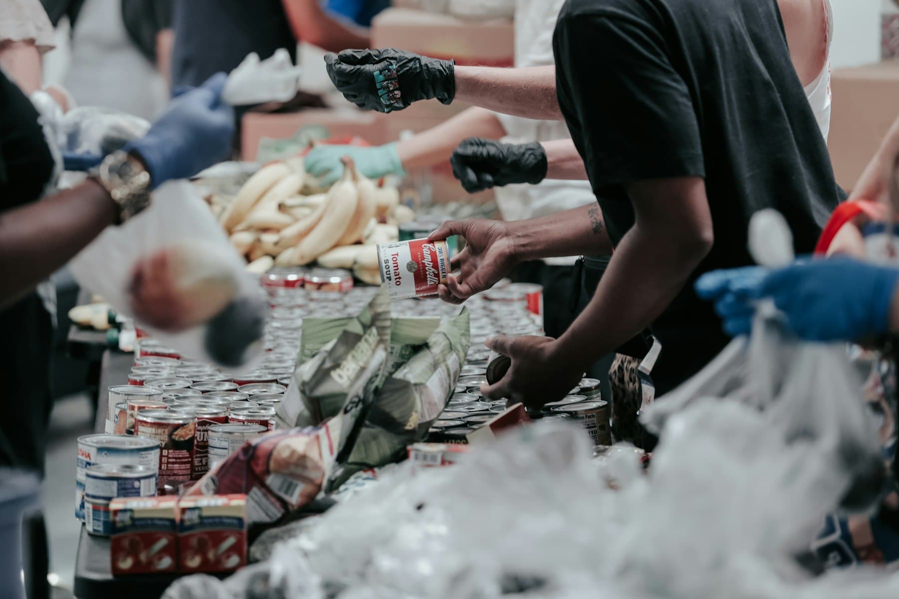 Volunteers sorting donated food into boxes at a community distribution table